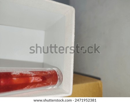 A beautiful bottle of red lip tint in the white box