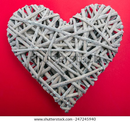 (withe, withy, osier, sallow, vine) braided on a frame in the form of hearts on a background of red cardboard - pictures concept theme Love and St. Valentine's Day