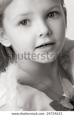 beautiful little girl with long hair and flower on dress, portrait closeup