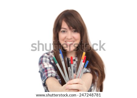 Young woman student holding pens against a white background