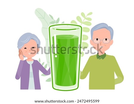 A smiling senior couple standing side by side with glasses of green juice between them. A positive image.