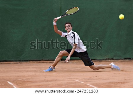 Male tennis player in action Royalty-Free Stock Photo #247251280