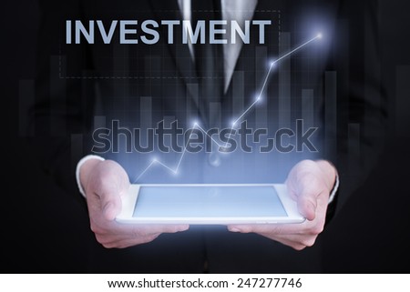 Businessman holding a tablet. with graphs and iinvestment and Financial Concept