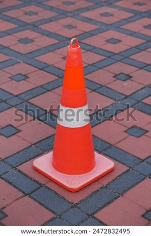 red safety cones on the red tile floor in the parking area in the morning