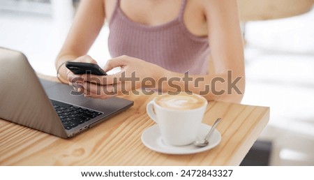 Hands, laptop and phone at coffee shop for remote work, communication and planning or search opportunity online. Freelancer or person typing on mobile app, chat or creative research at internet cafe