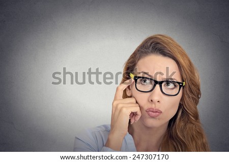 Can't remember. Headshot thoughtful young woman with glasses looking confused isolated grey wall background. Human face expression emotion feelings body language   Royalty-Free Stock Photo #247307170