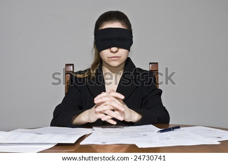 Blindfolded businesswoman signing papers