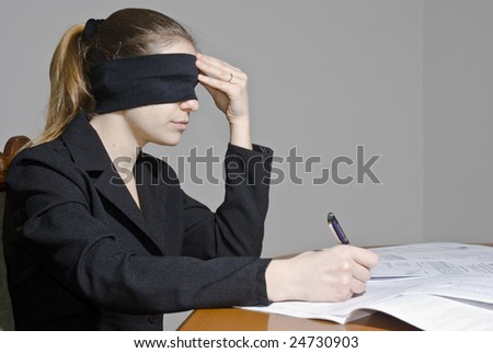 Blindfolded businesswoman signing papers