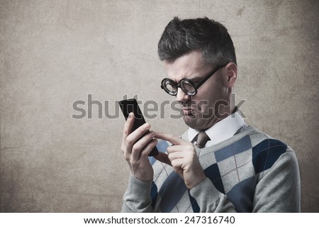 Funny clueless dumb guy having troubles with his smartphone Royalty-Free Stock Photo #247316740