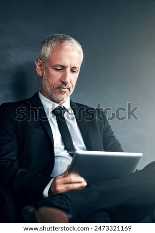 Man, tablet and reading on studio background for business, research for financial project or crypto. Male manager, mobile technology and planning for stock market, search or review of blockchain app