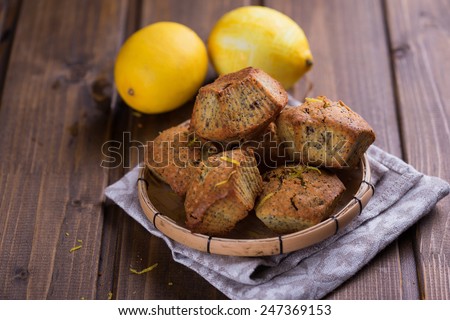 Fresh homemade muffins with lemon and poppy seeds  on painted wooden planks. Selective focus.