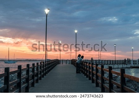 Summer vacations and adventure in La Paz Baja California Sur. Mexico. Sunset on the malecon at pier with rocks and boats by the sea of cortes, in front of EL MOGOTE