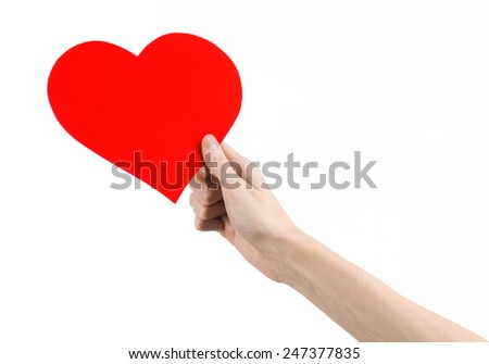 Valentine's Day and love theme: hand holding a red heart isolated on a white background in studio