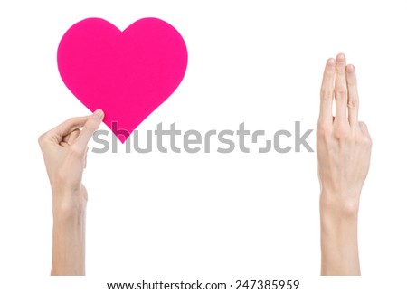Valentine's Day and love theme: hand holding a pink heart isolated on a white background in studio