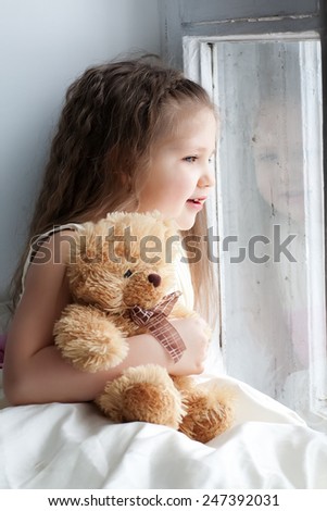 Girl with teddy bear in hand