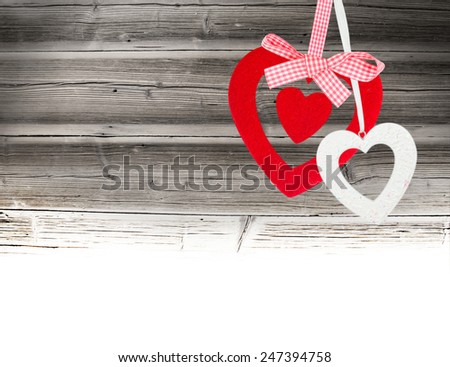 Hearts hanging on wooden background with white space