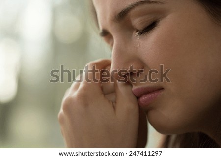 Close-up of young woman with problems crying Royalty-Free Stock Photo #247411297