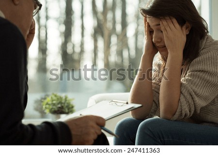 Portrait of glum girl during psychotherapy session Royalty-Free Stock Photo #247411363