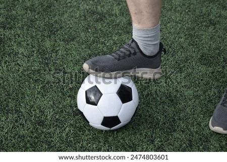 A young man in sportswear is playing soccer, training on a football pitch in the morning. Dedication and passion for the sport, the essence of morning exercise and practice outdoors