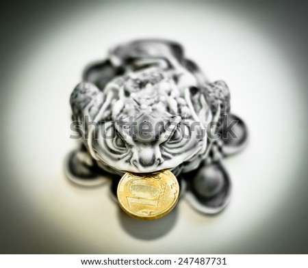 Traditional ?hinese money frog with Russian rouble coin in its mouth.