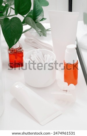 Cosmetics for face and body in jars and containers on a white table with plant, beauty product concept. Mockup.
