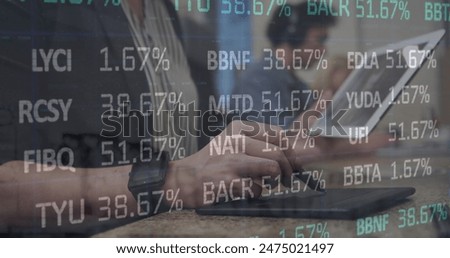 Image of stock market data processing against mid section of a woman using graphic tablet. Global economy and business technology concept