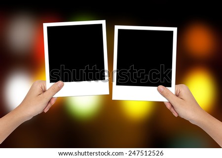 Blank photo frame on hand and colorful bokeh background