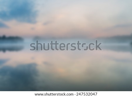 blurry landscape with lake at sunrise useful as background