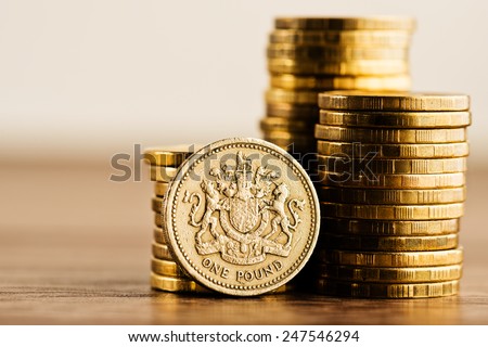 pound GBP coin and gold money on the desk Royalty-Free Stock Photo #247546294