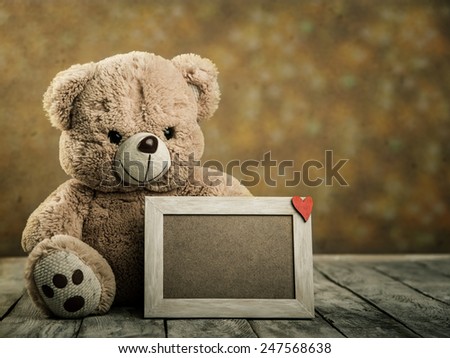 toy teddy bear with wooden photo frame with Valentine's symbol