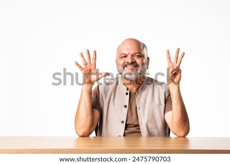 Indian asian handsome matured senior old man counting on fingers with smile on face