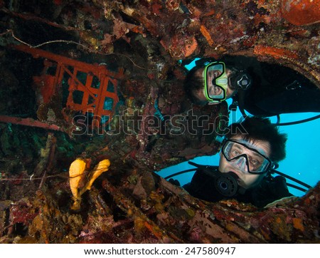 Scuba divers explore the underwater aircraft wreck, Palau, Micronesia Royalty-Free Stock Photo #247580947