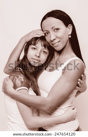 Portrait of a mother and daughter, family hug on a white