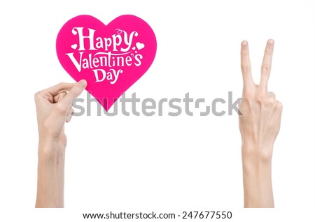 Valentine's Day and love theme: hand holds a greeting card in the form of a pink heart with the words Happy Valentine's day isolated on white background in studio