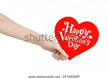 Valentine's Day and love theme: hand holds a greeting card in the form of a red heart with the words Happy Valentine's day isolated on white background in studio