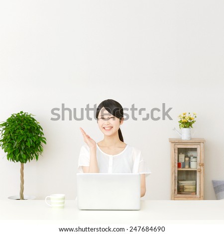 Japanese woman pointing up with PC