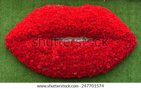 Valentines Day background with Mouth-shaped flowers of love on the background green grass.
