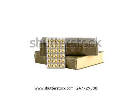 Two old medical books and new medicine pills in blister pack are isolated on white background
