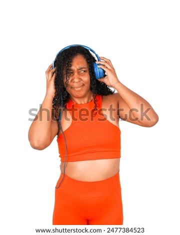 Frustrated young black fitness woman wearing blue headphones against a white background