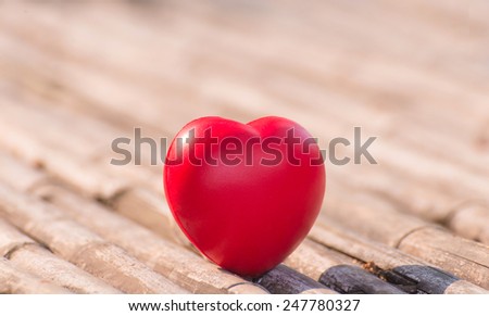 Red heart in love of Valentine's day with wood background.