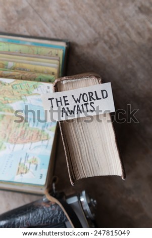 text "The World Awaits" and book, travel, tour,tourism concept