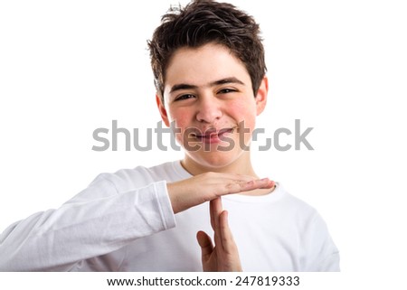 Hispanic boy with acne-prone skin in a white long sleeved t-shirt smiles making timeout gesture
