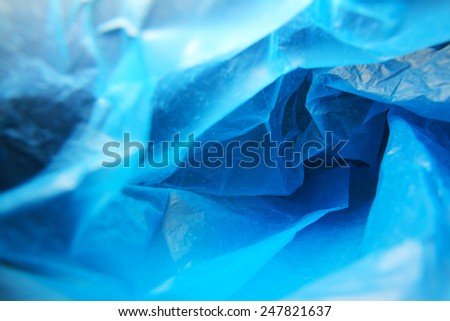Abstract background of the insides of a blue plastic bag with different color shades