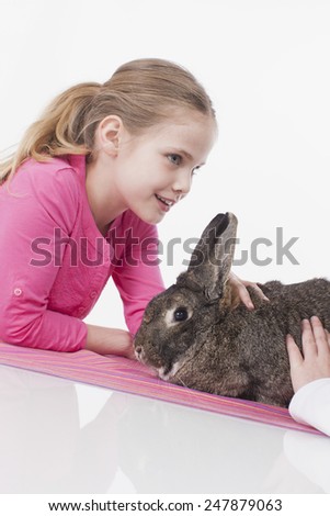 Girl and Boy holding rabbit, smiling