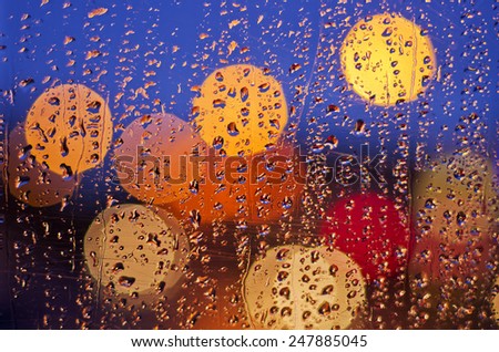 Night city life through windscreen: darkness and rain
