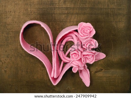 Bouquet of roses and heart silhouette on the wooden background