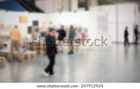 People visit an art gallery. Intentionally blurred post production.
