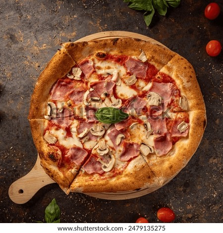 Delicious pizza with ham and mushrooms staying on a rustic board