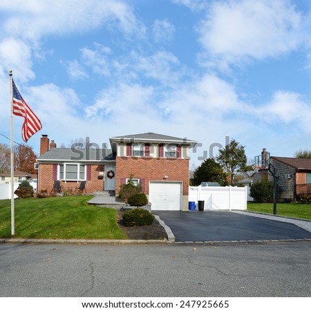 Beautiful Suburban Brick Snout style home landscaped yard residential neighborhood USA blue sky clouds