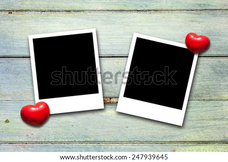Blank valentine photo frames on wood background